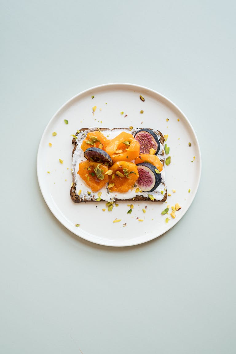 A stylish gourmet toast topped with figs, apricots, and nuts, ideal for breakfast.