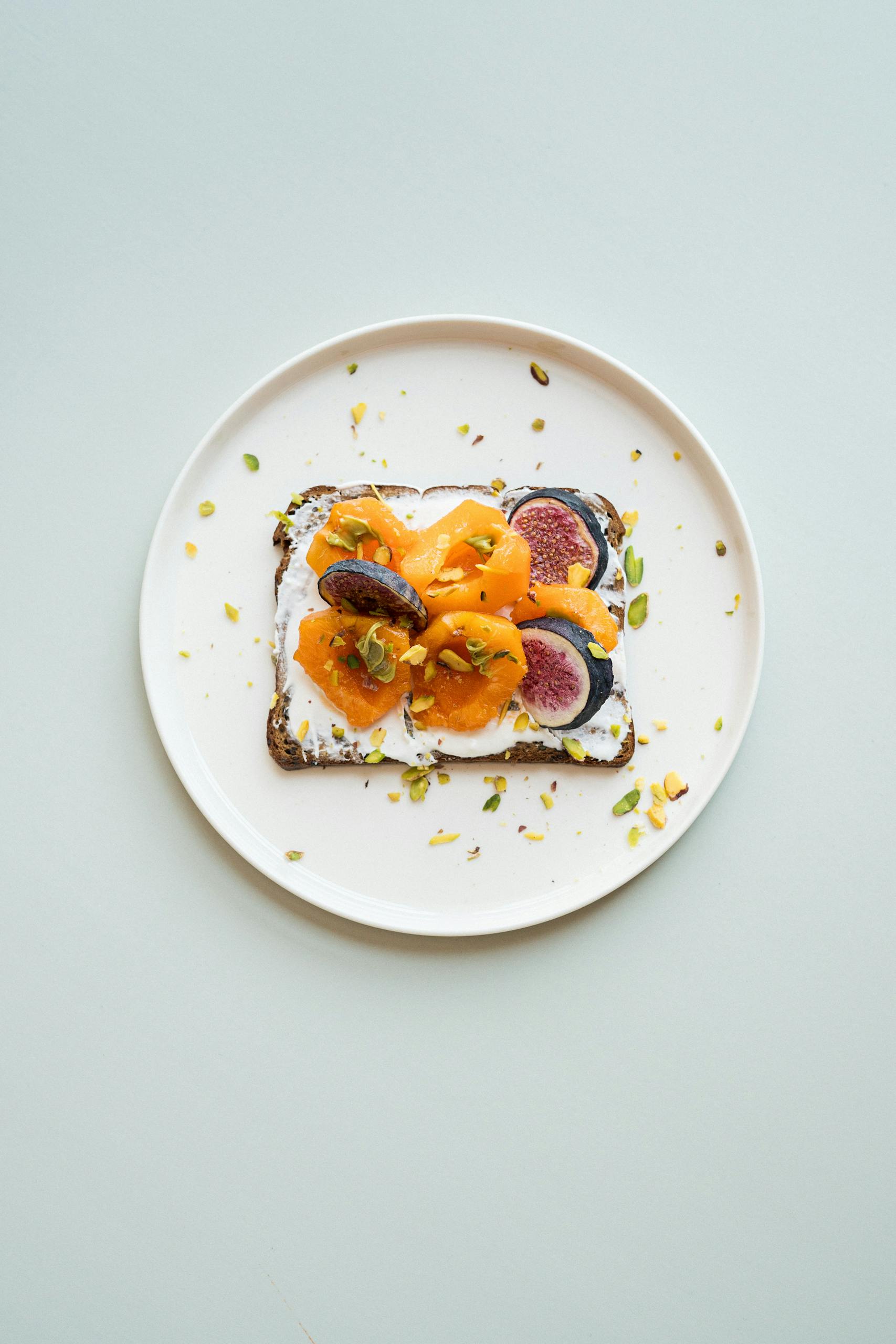 A stylish gourmet toast topped with figs, apricots, and nuts, ideal for breakfast.