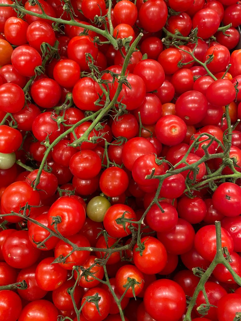 A vibrant display of fresh organic cherry tomatoes with vines.