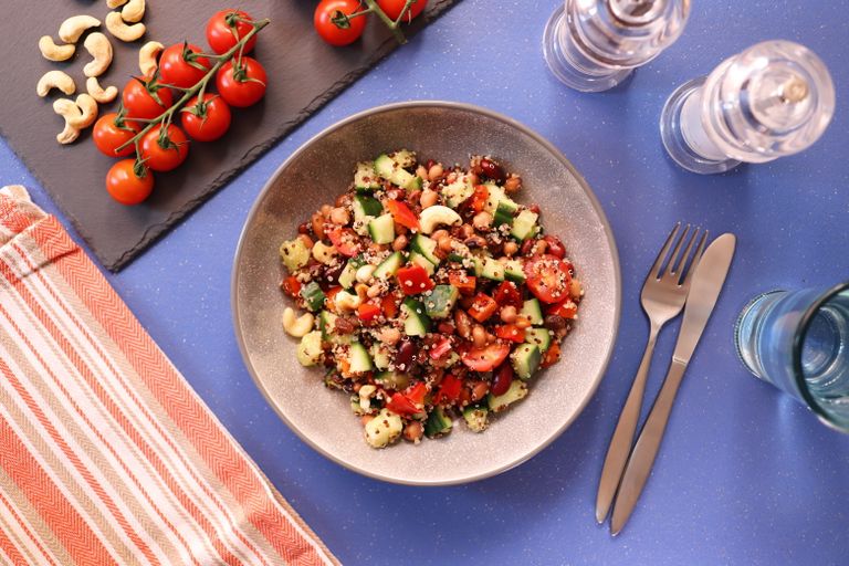 Colorful quinoa salad with cherry tomatoes, cucumbers, and cashews for a nutritious meal.