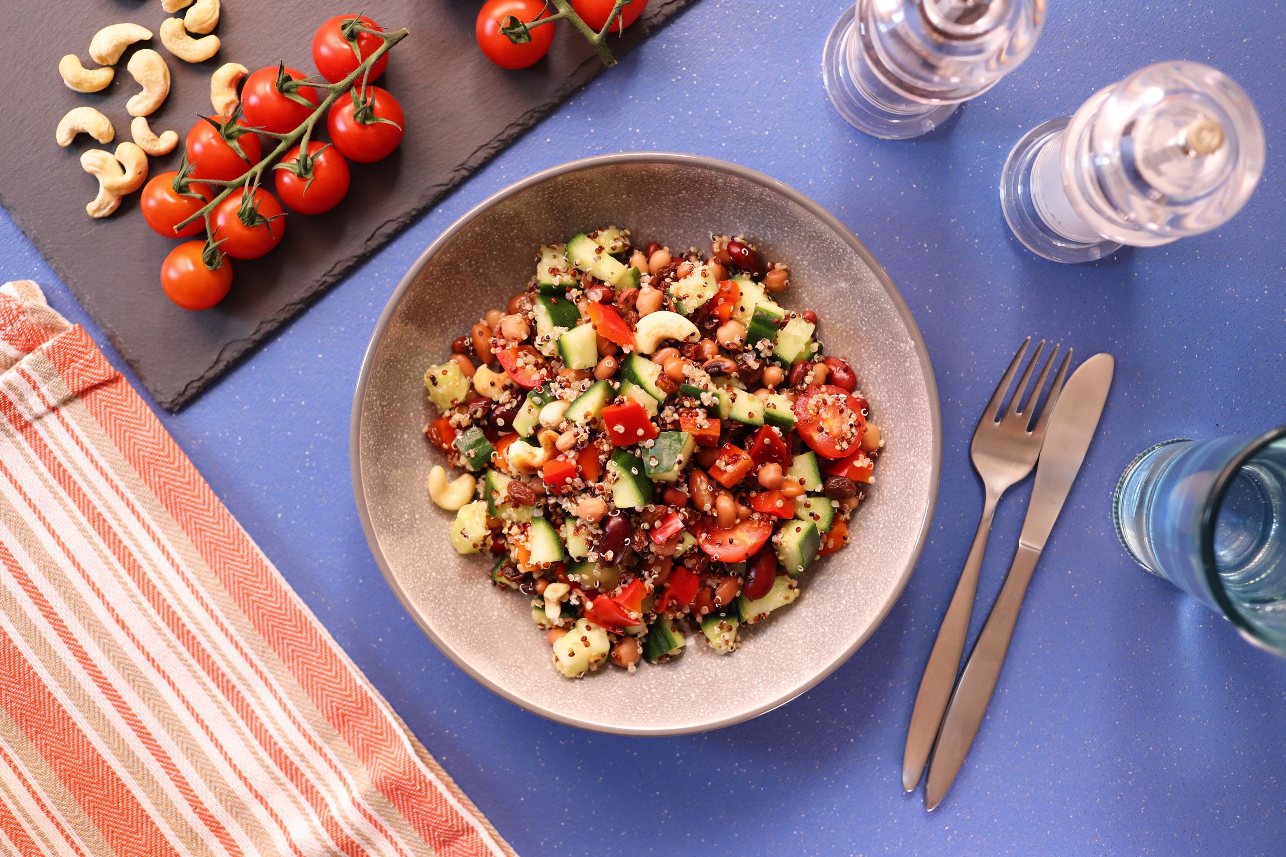 Colorful quinoa salad with cherry tomatoes, cucumbers, and cashews for a nutritious meal.