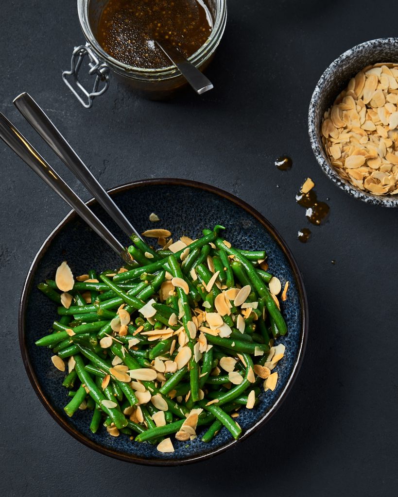 Green beans tossed with sliced almonds and dressing, perfect for a tasty side dish.