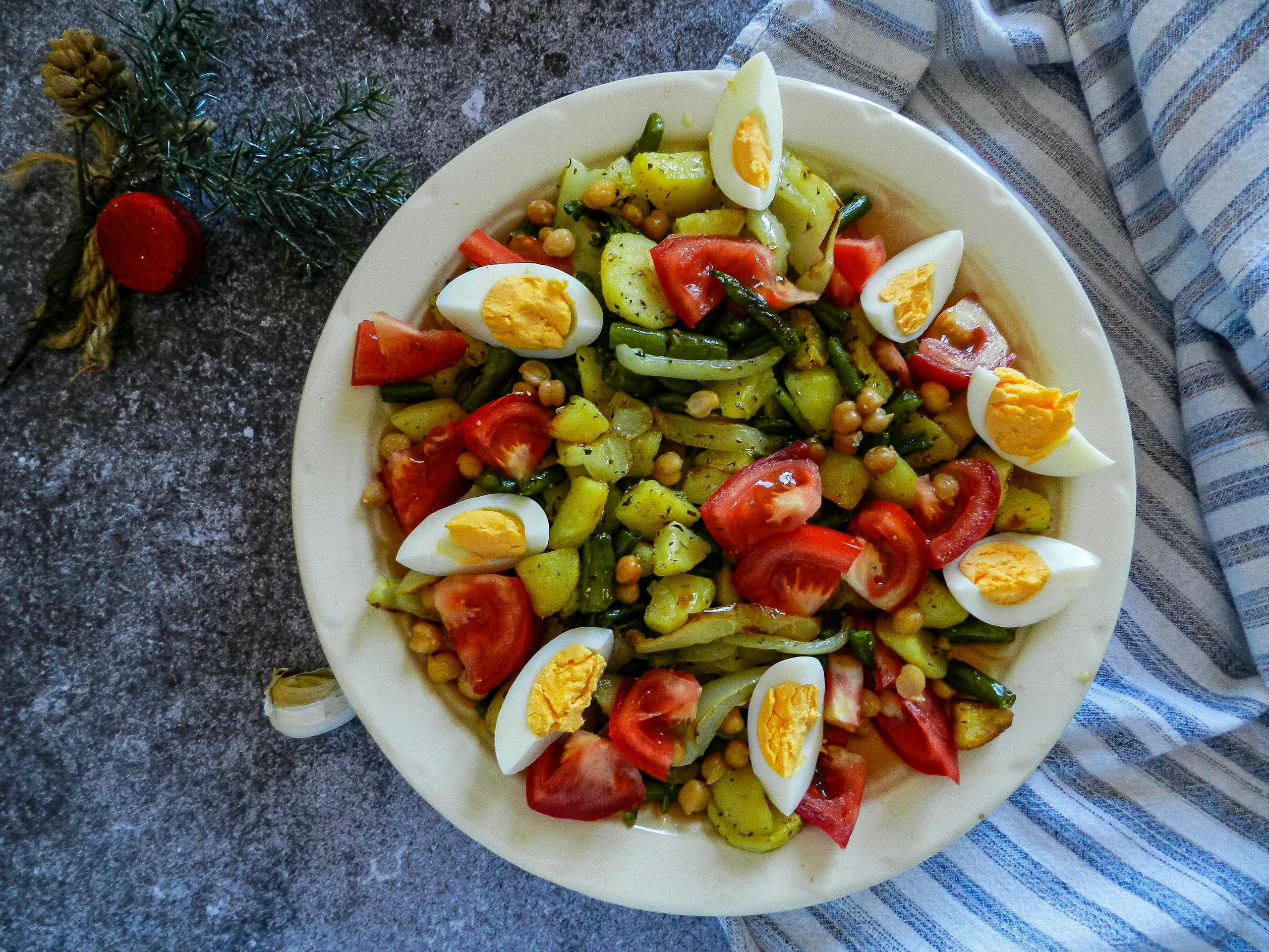 Healthy vegetable salad with chickpeas, tomatoes, and eggs, perfect for a nutritious meal.