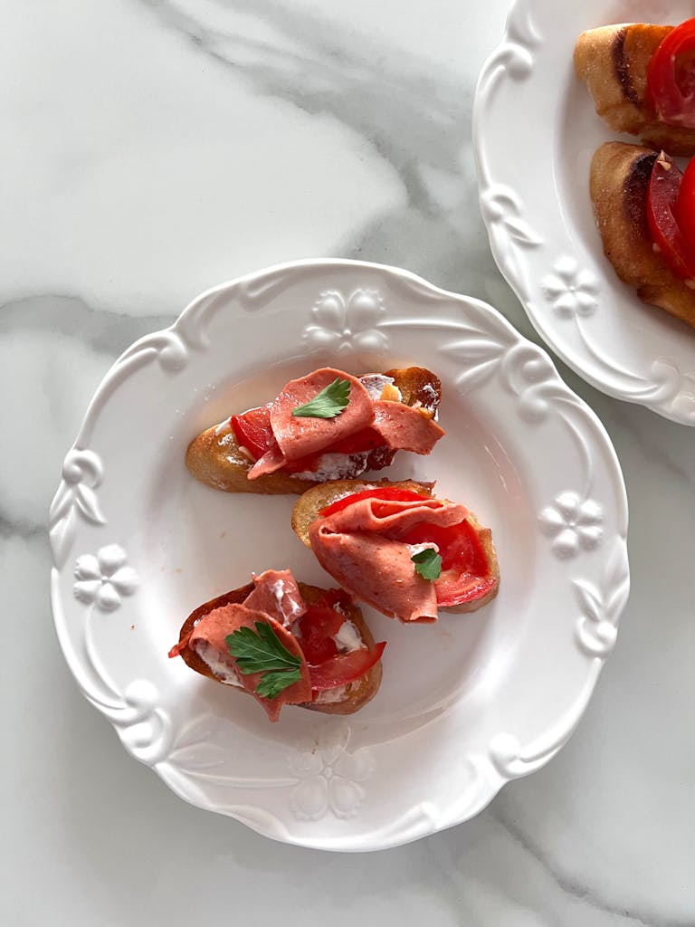 Tasty bruschetta with fresh tomato and herbs on an elegant white plate. Ideal for Italian cuisine enthusiasts.