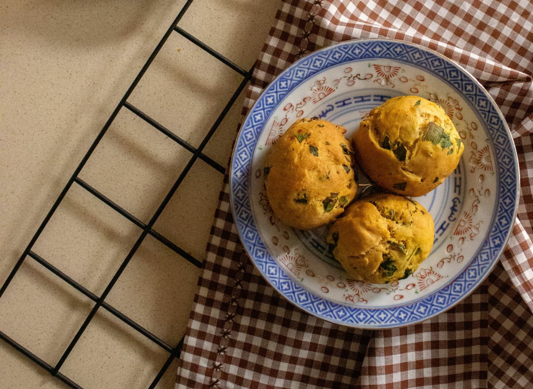 Top view of muffins on a ceramic plate with tea, set on a rustic table. Perfect for cozy moments.