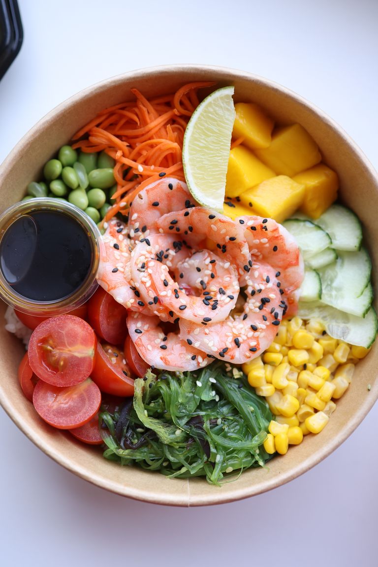 Vibrant poke bowl featuring shrimp, mango, and vegetables for a healthy meal option.