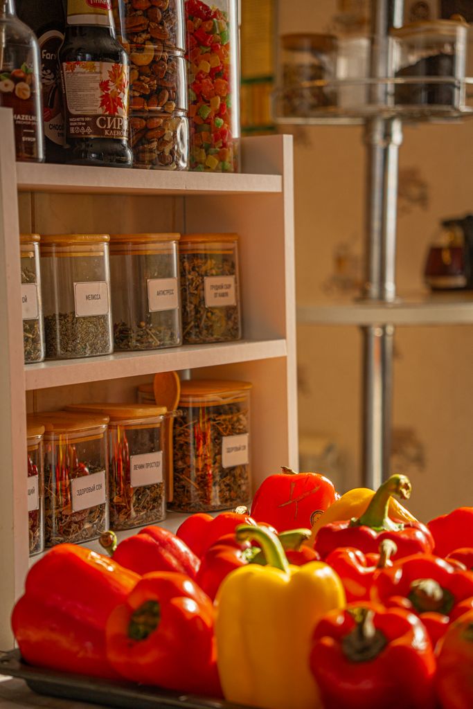 Vibrant red, yellow bell peppers with spice jars in a sunlit kitchen setting.