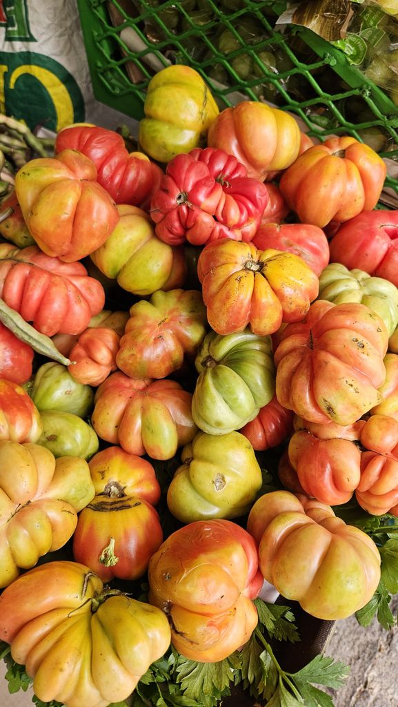 Vivid assortment of heirloom tomatoes at a market exhibit vibrant colors and textures.