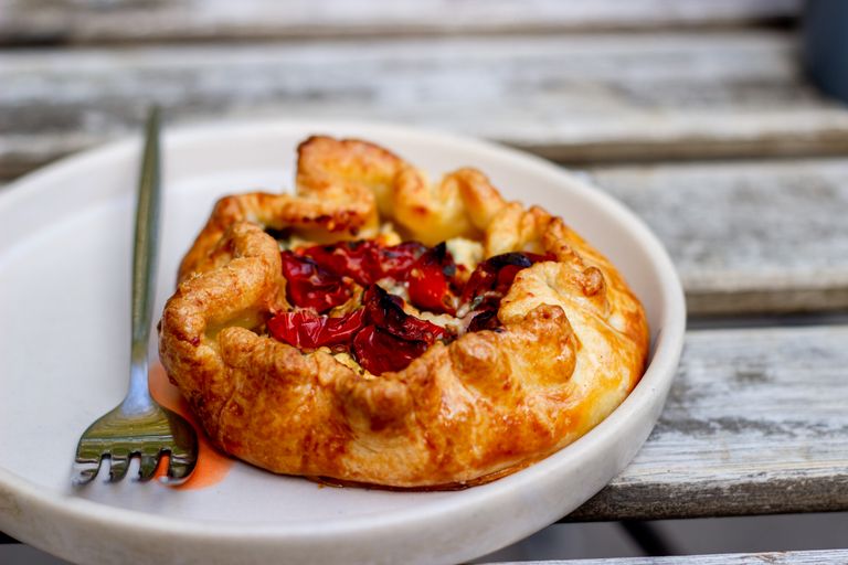 A delicious tomato galette on a plate with a fork, perfect for a gourmet meal.