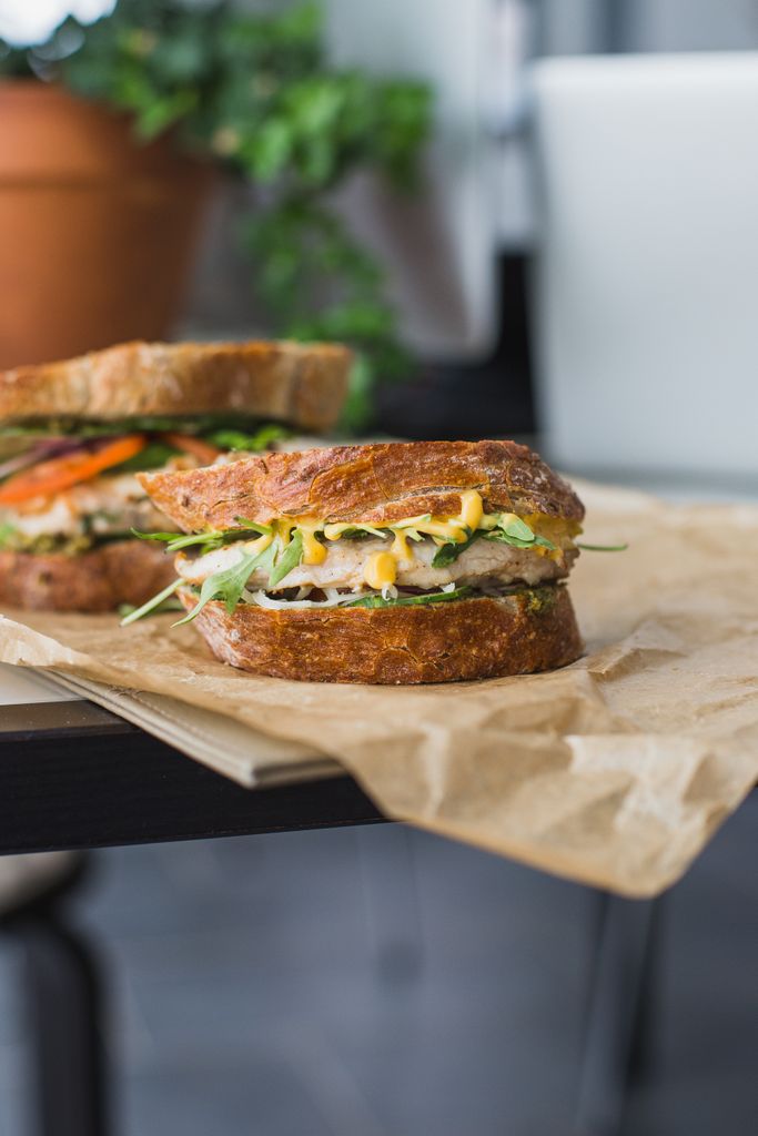 Close-up of gourmet sandwich with fresh veggies on rustic bread, ideal for food photography.