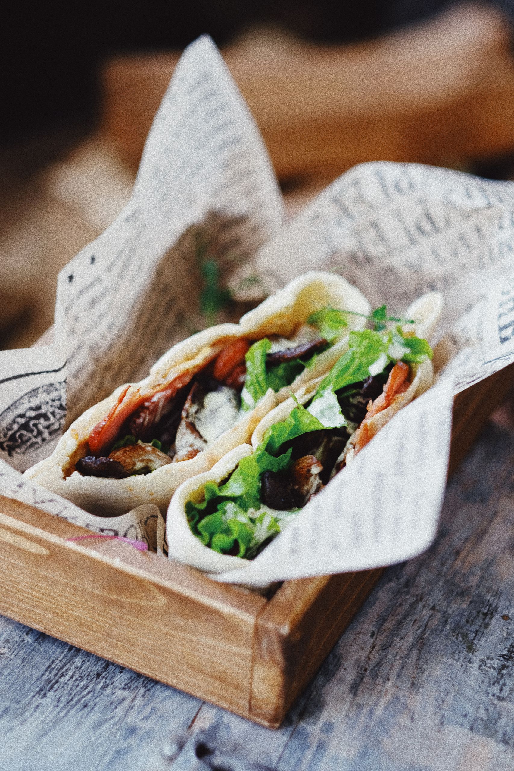From above of delicious appetizing veggie pita bread sandwich stuffed with tomatoes cucumbers olives and cheese and served on wooden tray in cafe