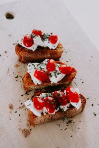 Savor the visually appetizing and classic Italian bruschetta topped with fresh tomatoes and cheese, perfect for gourmet food presentations.