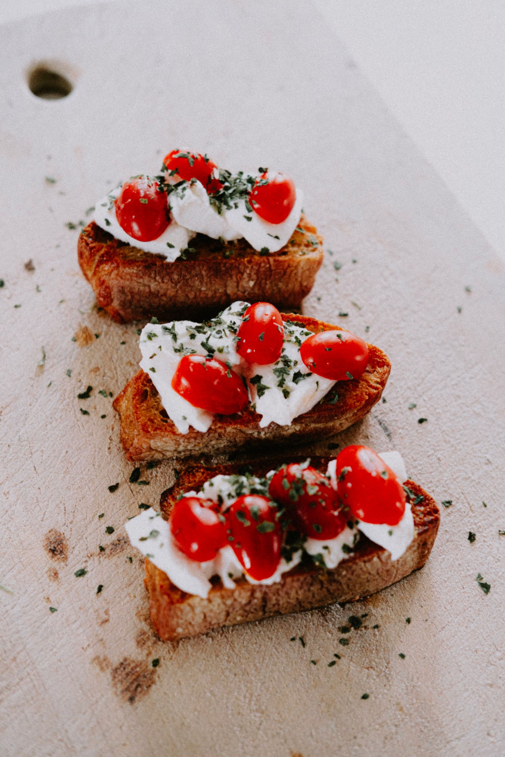 Savor the visually appetizing and classic Italian bruschetta topped with fresh tomatoes and cheese, perfect for gourmet food presentations.