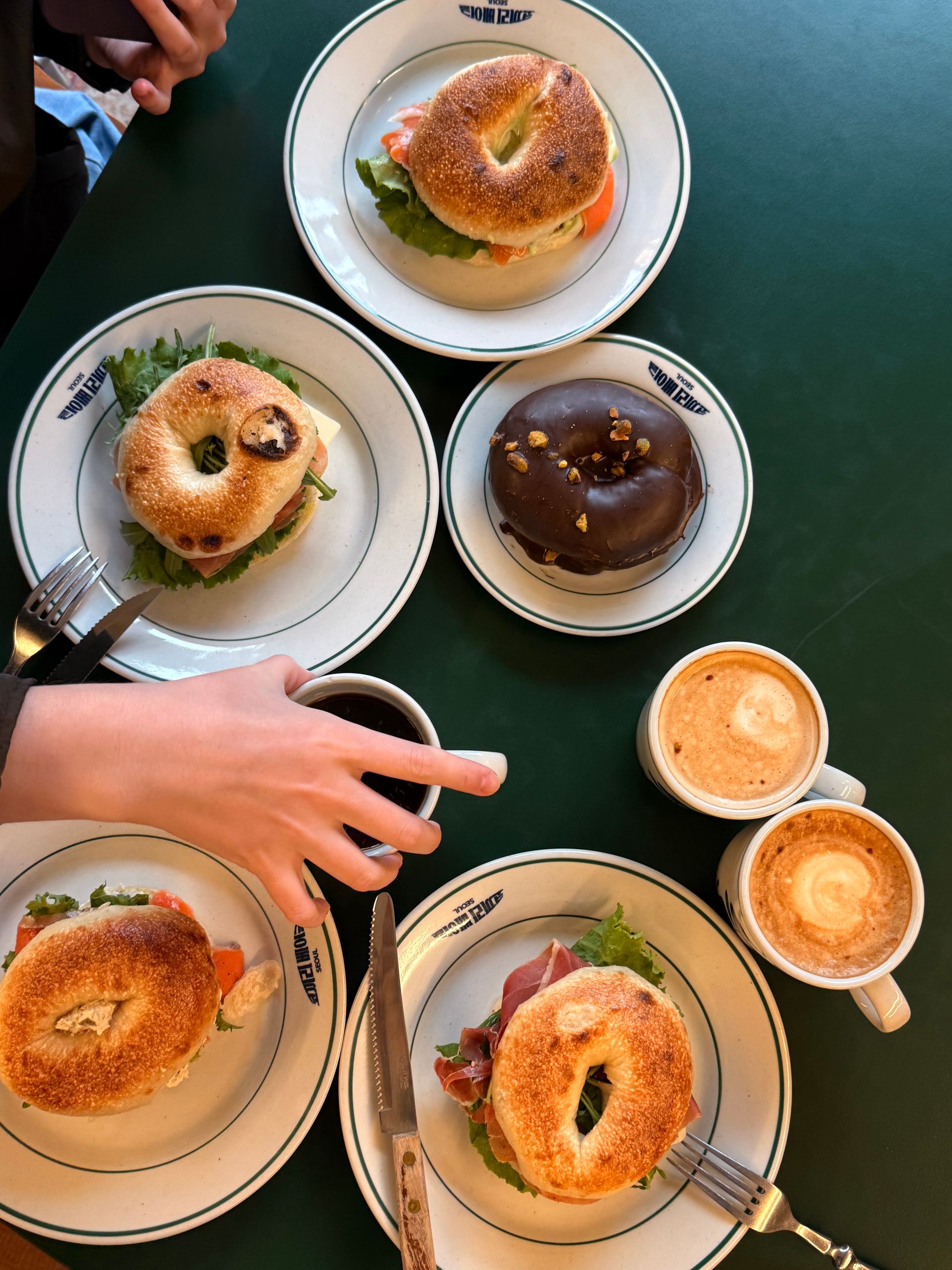 Top view of bagels and coffee cups on a table, creating a cozy breakfast scene.