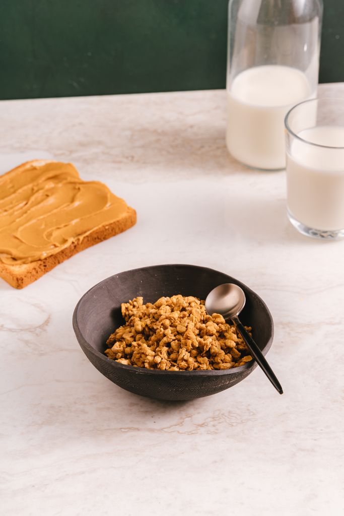 A delicious and nutritious breakfast of granola with milk, served with peanut butter toast.