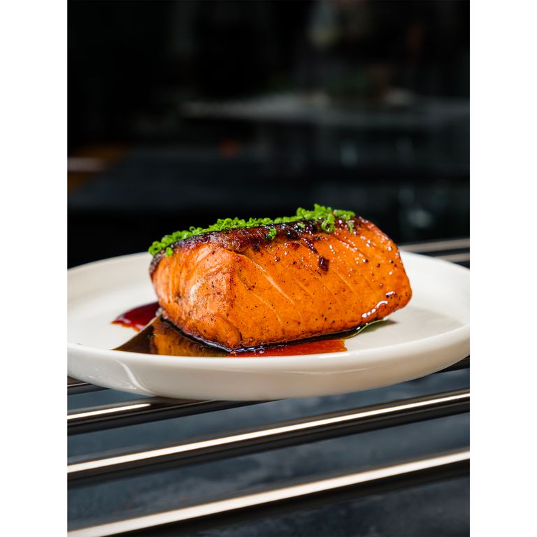 A mouthwatering close-up of a grilled salmon fillet with garnishing herbs, shot in Antalya.