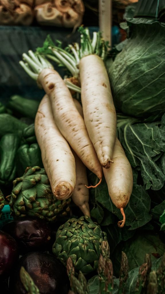 A vibrant assortment of fresh radishes, artichokes, and greens at Zacapoaxtla, Mexico market.
