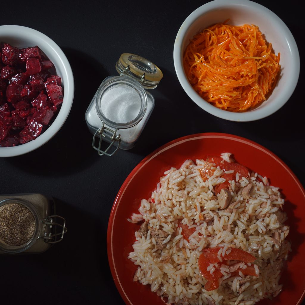 A vibrant assortment of rice, carrots, and beets in a flat lay, showcasing Provence flavors.