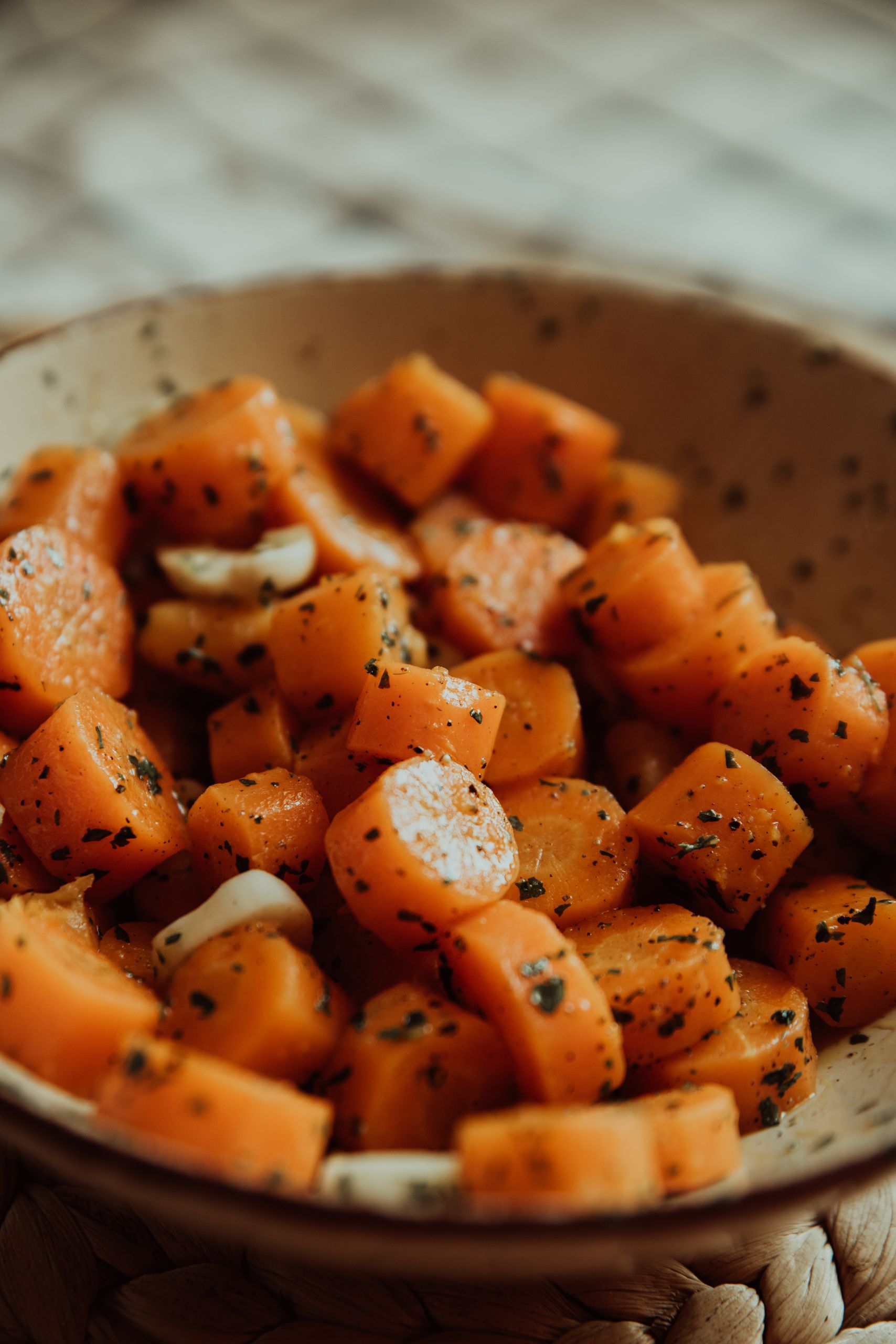 Close-up of freshly chopped carrots in a rustic bowl, showcasing vibrant orange hues and healthy meal preparation.