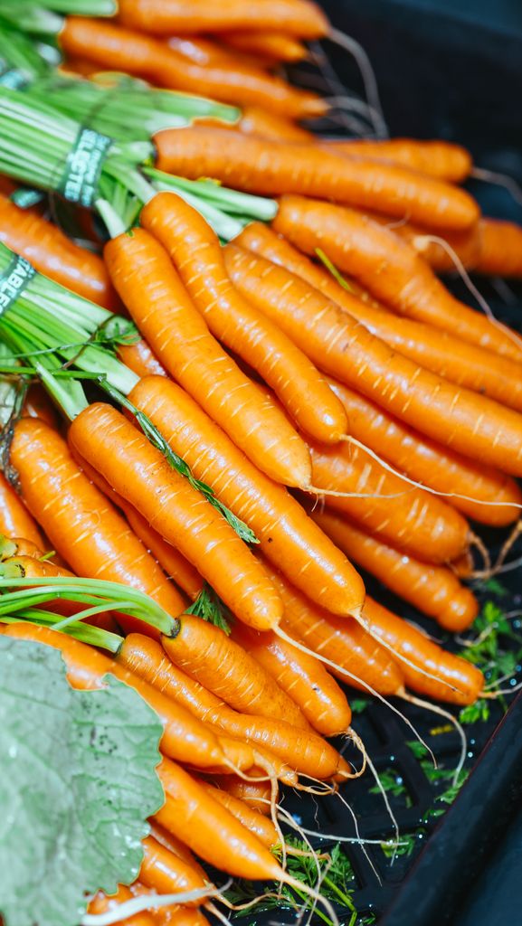 Close-up of freshly harvested carrots neatly stacked, showcasing vibrant color and healthy produce.