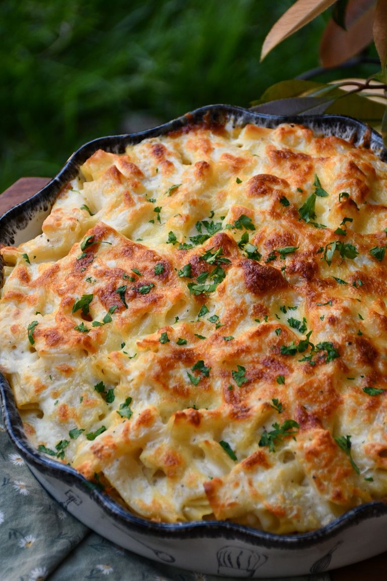 Delicious baked cheesy pasta garnished with fresh parsley, perfect for a hearty meal.
