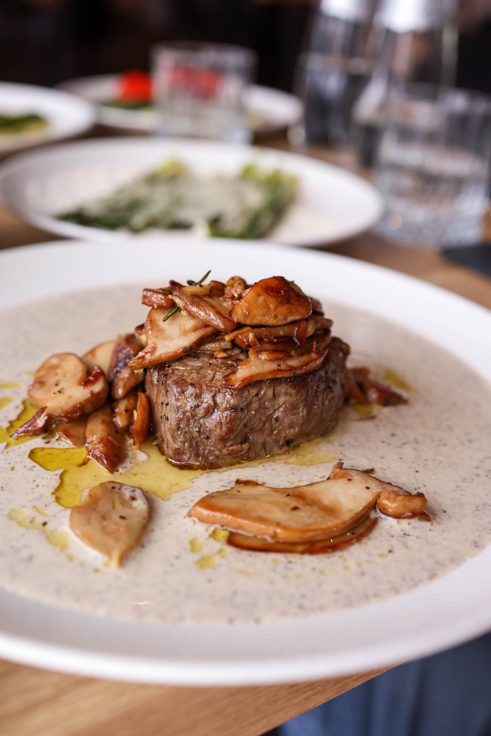 Delicious fillet steak served with wild mushrooms and creamy sauce on a plate in a restaurant.