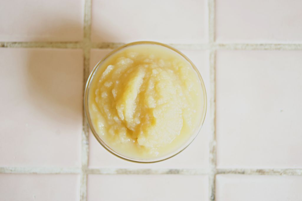 Top view of a bowl of fresh, homemade applesauce on a tiled surface.