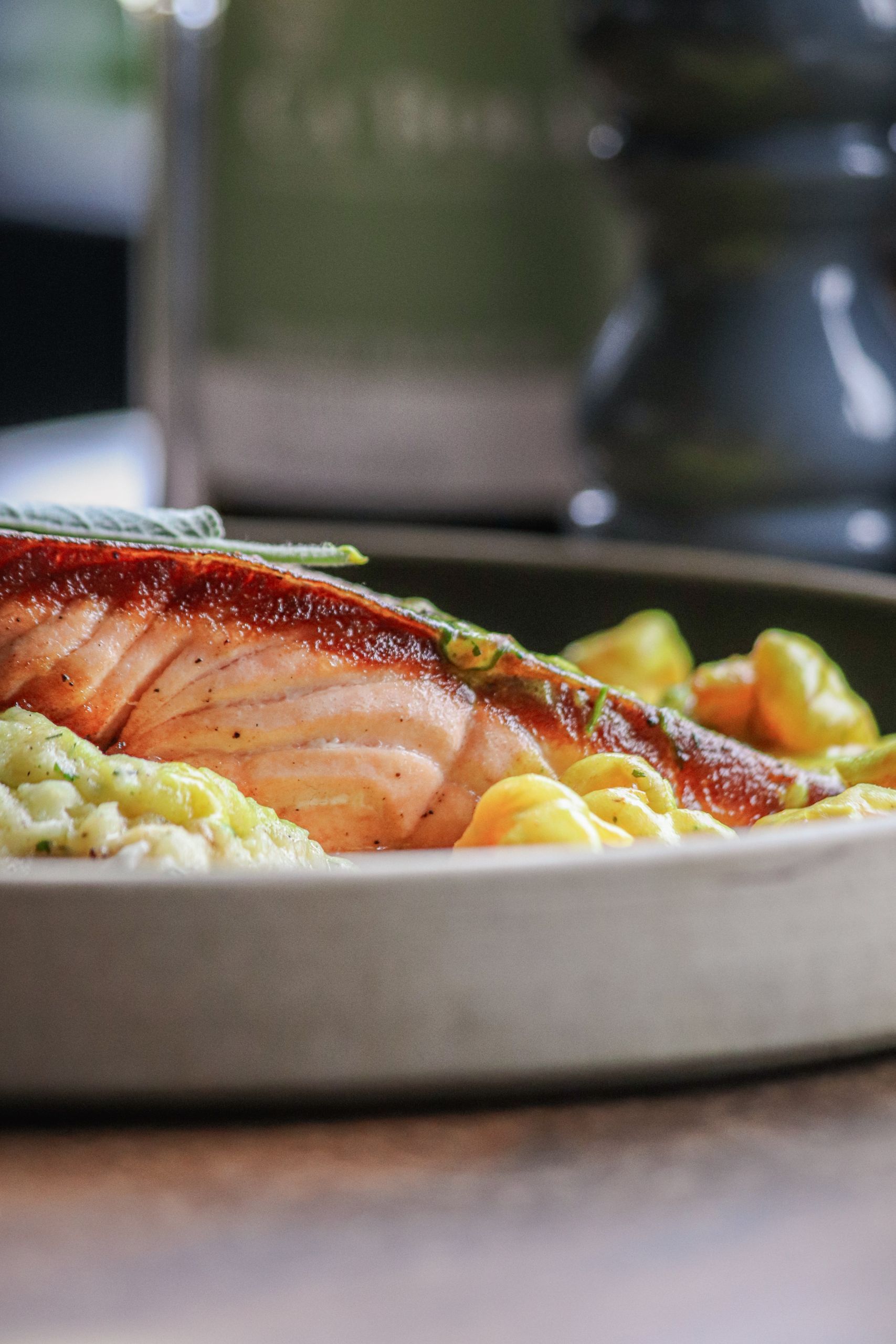 Delicious grilled salmon fillet served with mashed potatoes and vegetables on a plate.