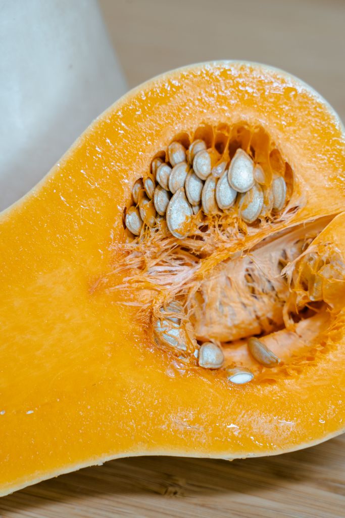Detailed image of a freshly cut butternut squash showcasing seeds and texture.