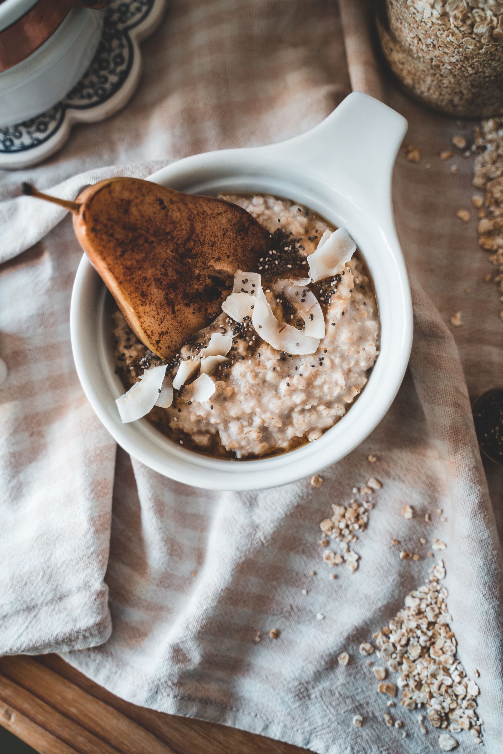 Elevate your morning with a beautifully styled oatmeal bowl featuring pear and coconut flakes.